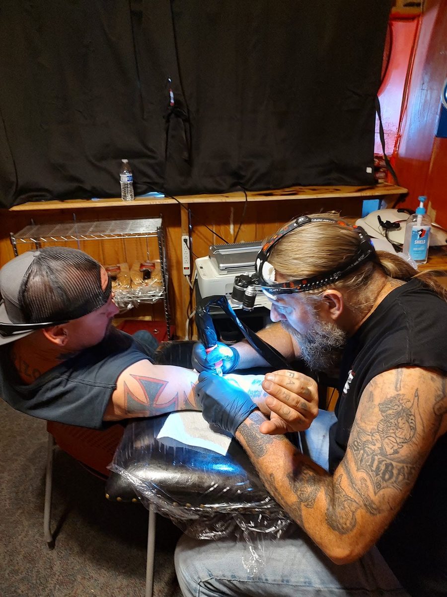 Bert at the machine, working on a client's forearm