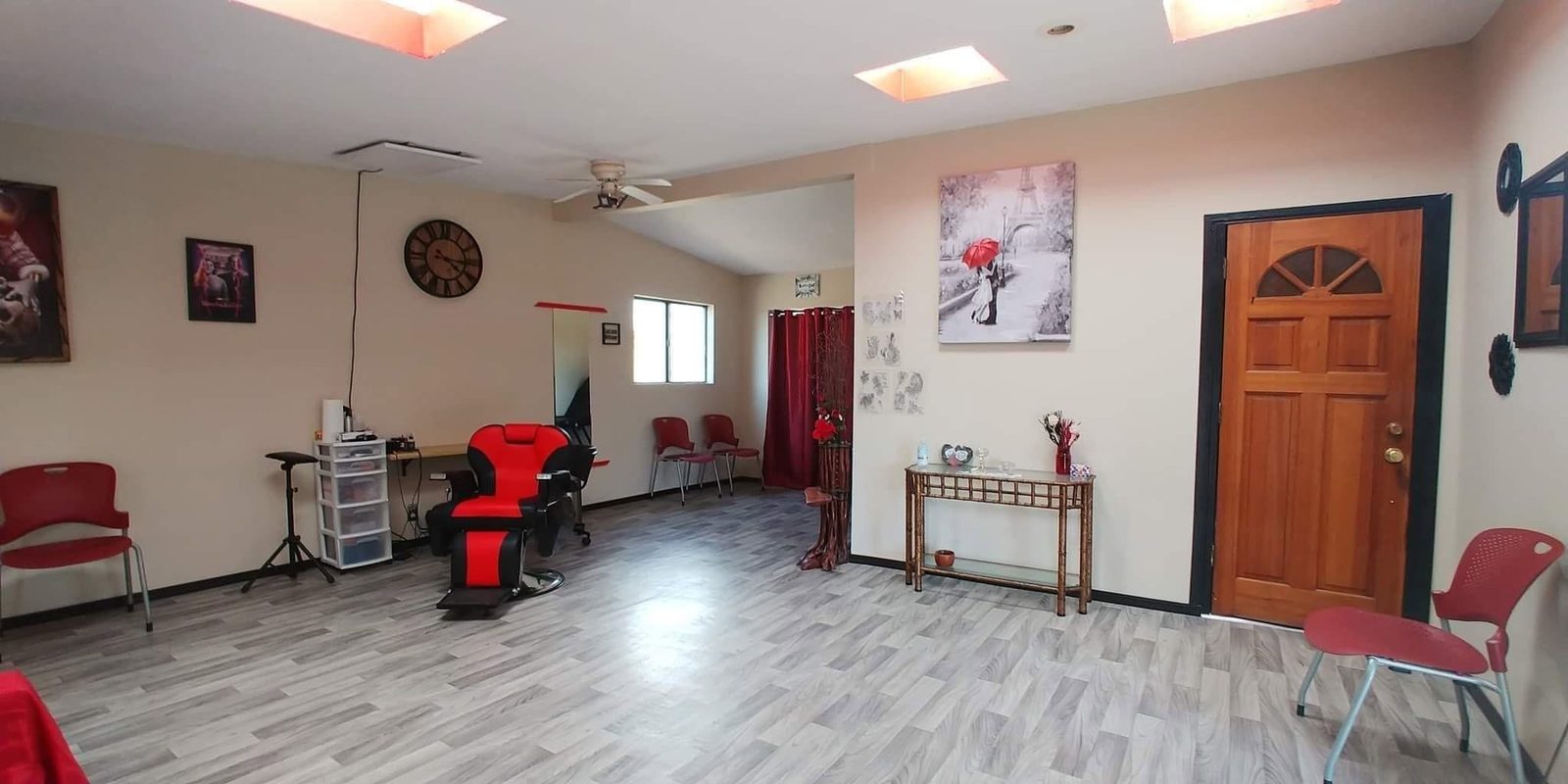 The front room at Bert's Ink: red chairs, the door, and the chair set up in the middle