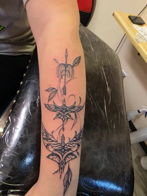 Avatar banshees and an arrow with feathers down the inner forearm, black line work