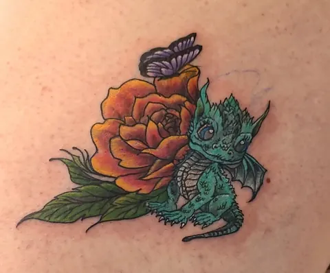 Baby dragon curled beside an orange rose with a butterfly, in color