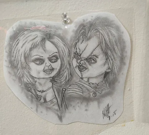 Pencil drawing of two horror movie dolls on tracing paper