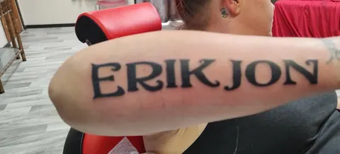 Bold block lettering on the forearm