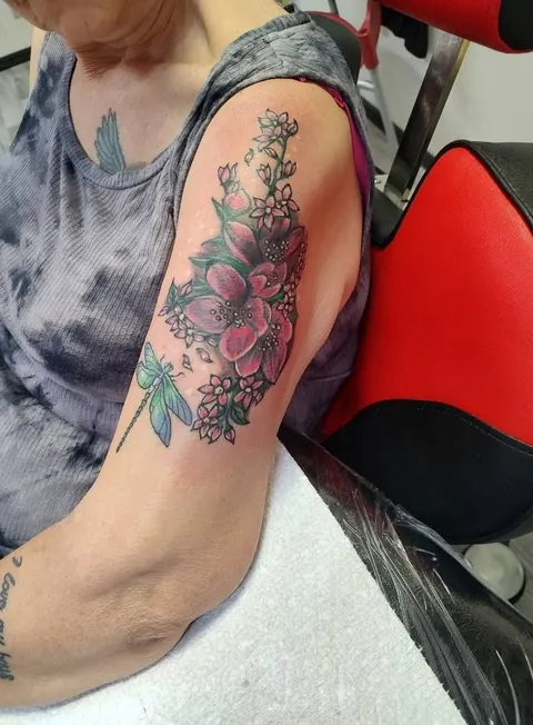 Flowers and a dragonfly on the upper arm, in color