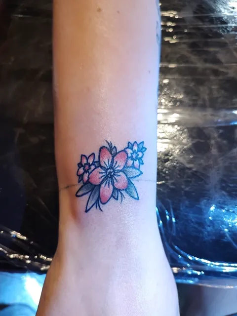 Pink and blue flowers on the inner wrist, in color