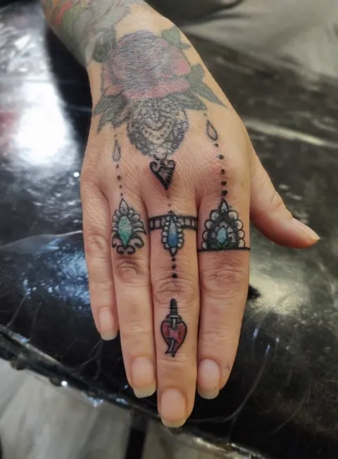 Rings, jewels and a rose across the back of the hand and the fingers