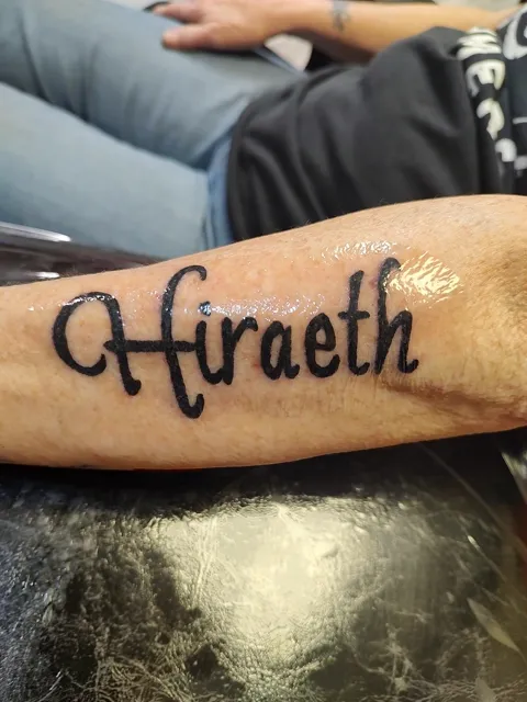 The word Hiraeth in script along the forearm