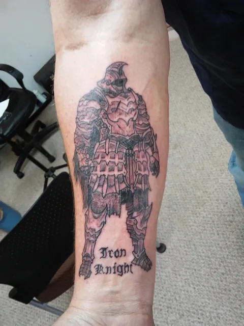 An armored knight above the words Iron Knight on the forearm, black and gray
