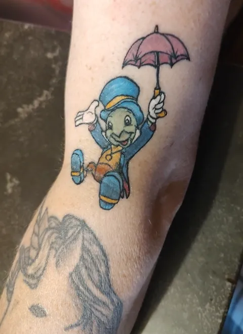 Jiminy Cricket with his umbrella on the forearm, in color