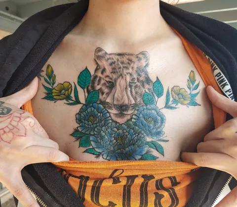 Leopard face framed in blue flowers across the chest, in color