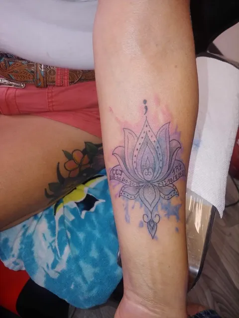 A purple lotus in watercolor on the forearm