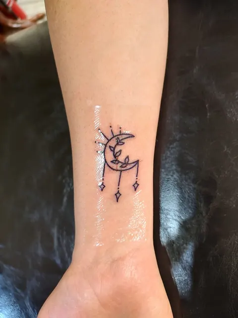 Crescent moon with hanging stars on the wrist, fine line