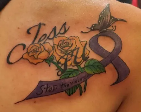 A name in script with yellow roses, a purple awareness ribbon and a butterfly