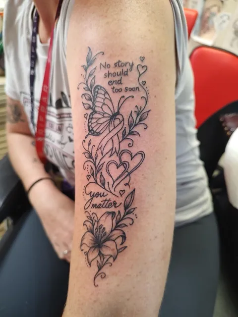 The words No story should end too soon and You matter, with a butterfly, hearts and lilies down the arm, fine line