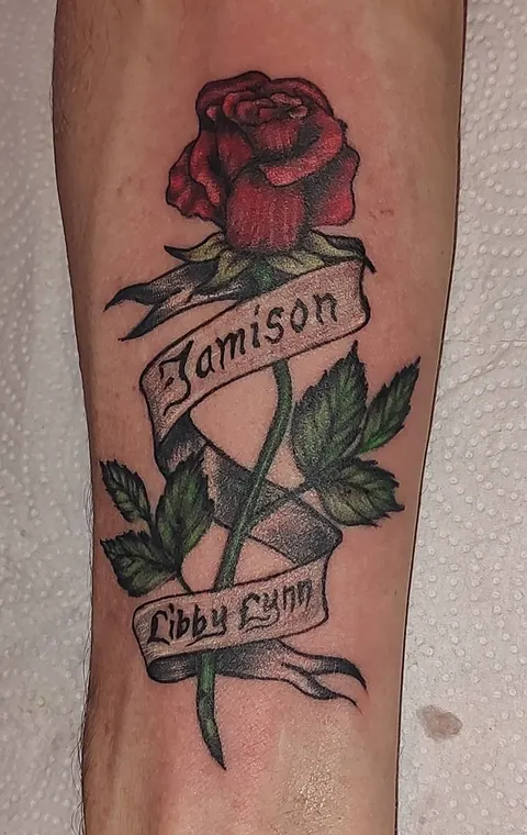 Red rose with two name banners on the forearm, in color
