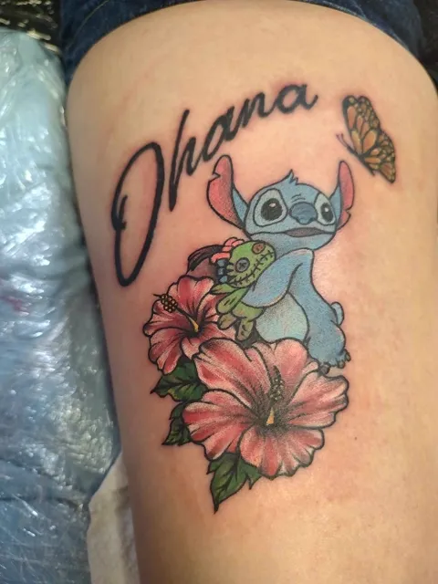 Stitch with a hibiscus and a butterfly under the word Ohana, in color