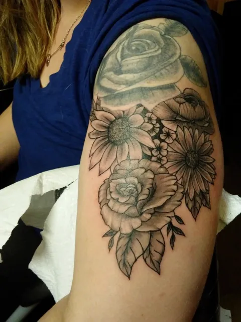 Sunflowers and roses on the upper arm, black and gray