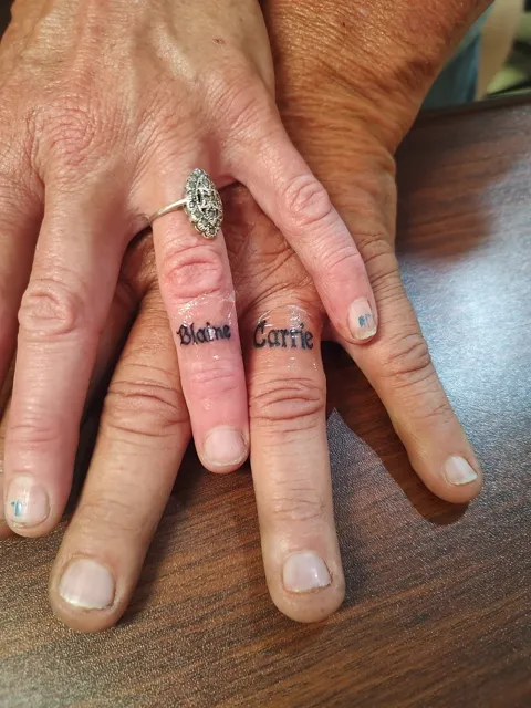 Two names in script on two ring fingers
