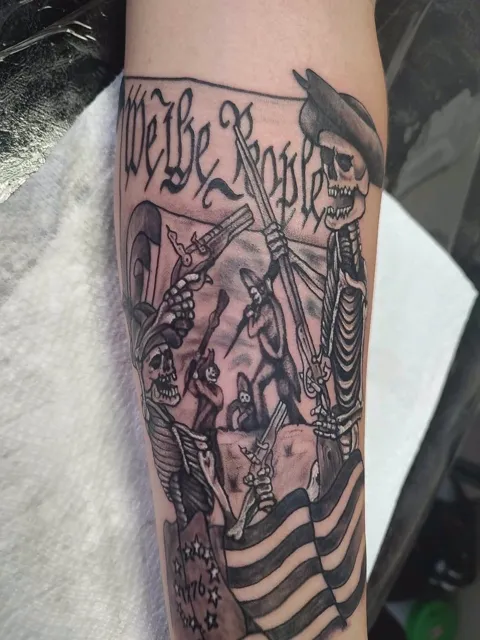 We the People above skeleton minutemen and a flag on the forearm, black and gray