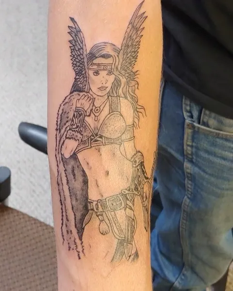 A winged warrior woman down the forearm, black and gray